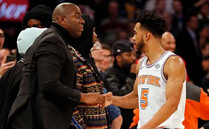Johnson (L) greets then-Knicks guard Courtney Lee prior to a game at Madison Square Garden.